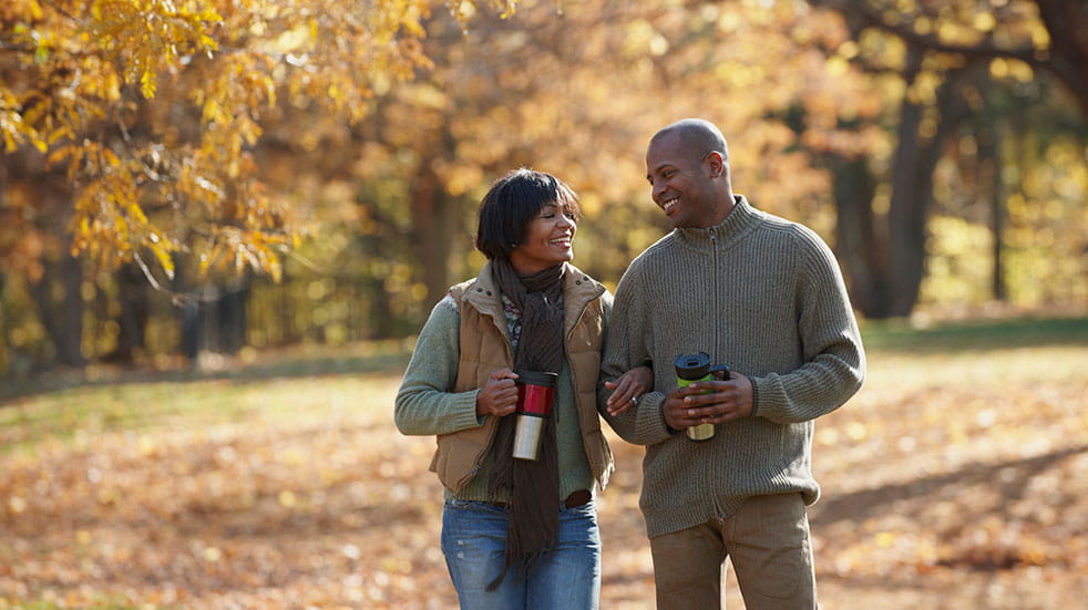 Autumn and winter wellness couple smiling walking